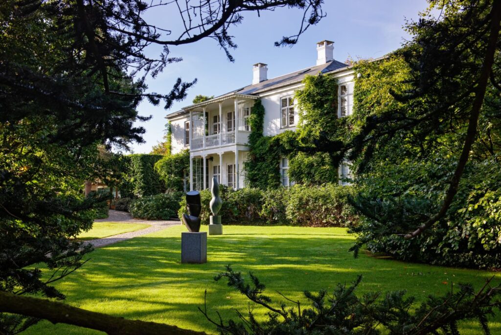 white building with green garden and sculptures