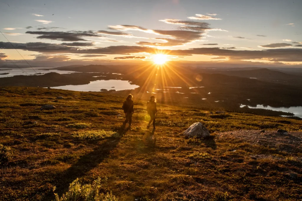 people hiking in mountains during sunset