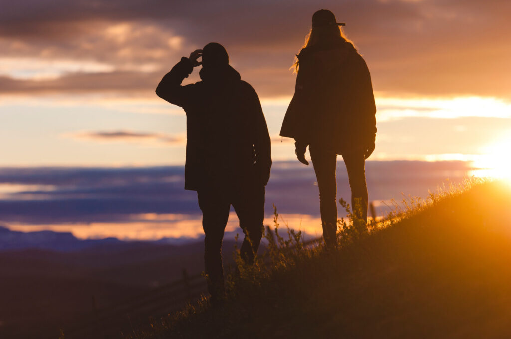 two people watching sunset over mountain