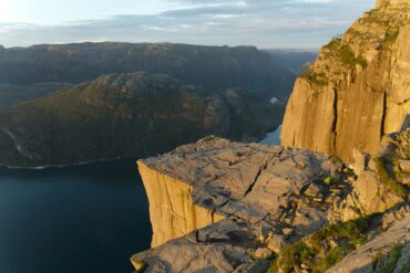 rock with people and water during sunset