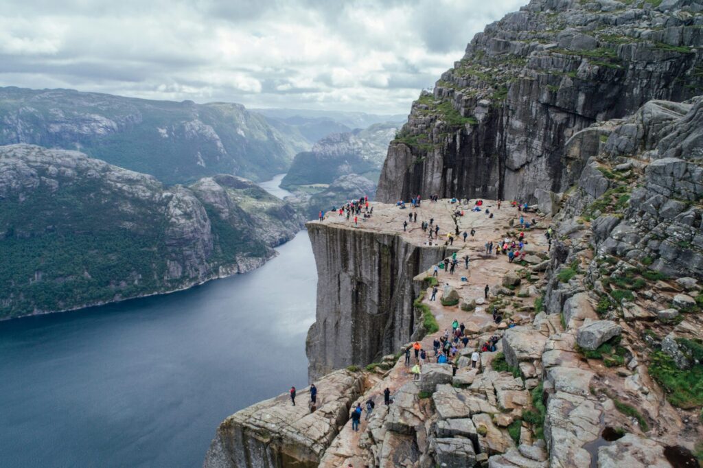 rock with many people near fjord