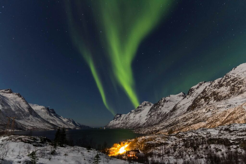 northern lights above mountains in snow