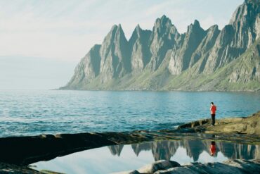 man with view of the mountains by the sea