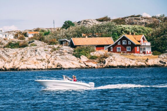 white speedboat in front of a red house