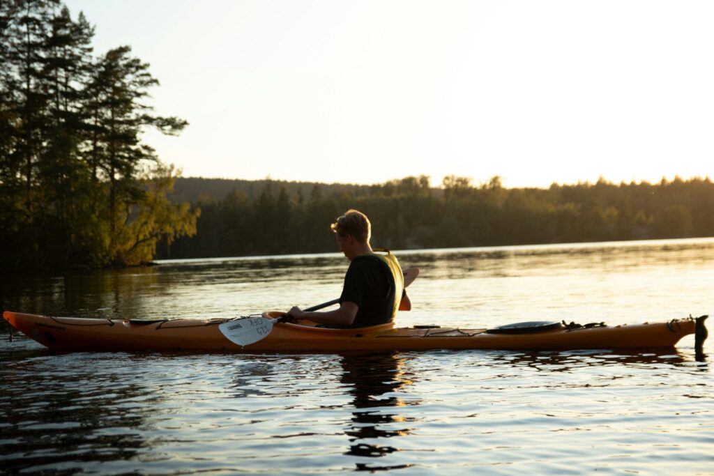 person in kayak at sunset in lake