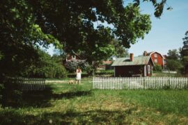 girl in sweden in front of red cabin