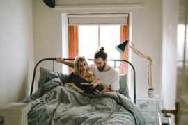 man and woman in bed reading a book
