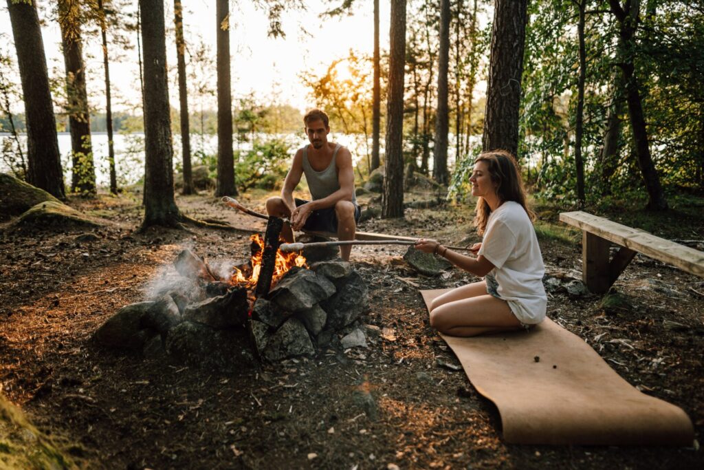 a man and woman sitting around a fire