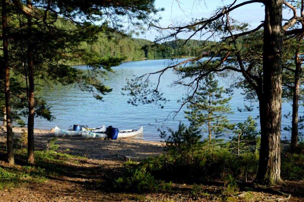 a couple canoes sitting on the side of a Swedish lake