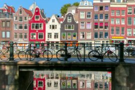 coloured houses in front of a canal with bikes in the netherlands