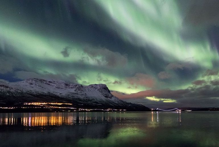 See the lights refelectd in  Lake Torneträsk on a northern lights tour from Abisko