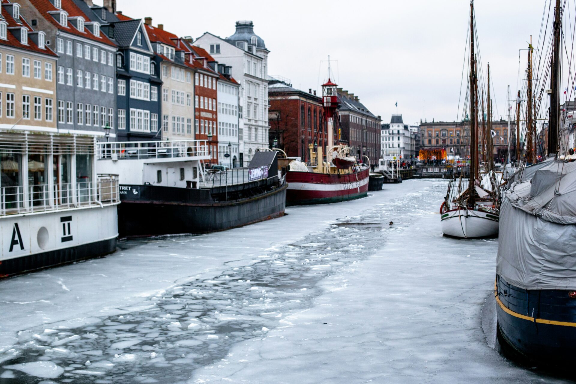 several boats docked in a frozen canal in copenhagen