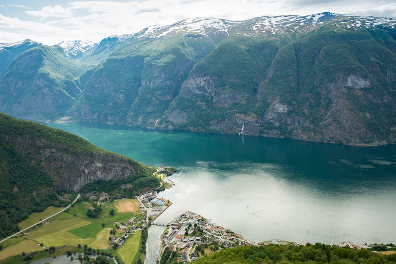 Flåm sits on the shores of a fjord surrounded by mountains