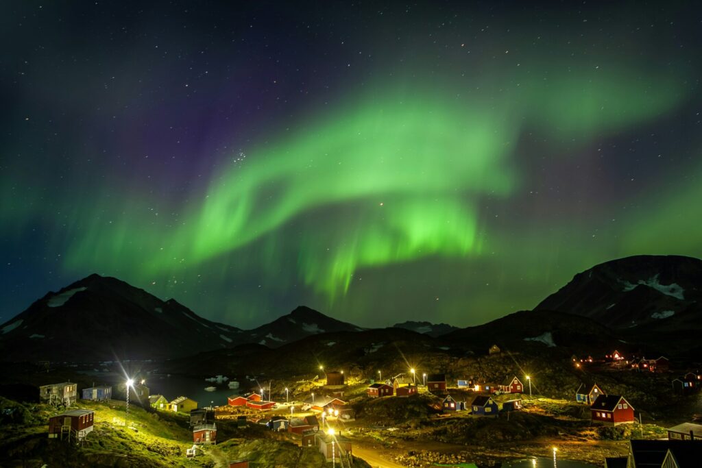 northern lights above a village in the mountains
