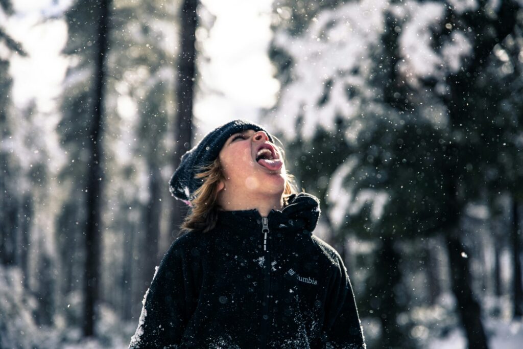 girl catching snowflakes with tongue out