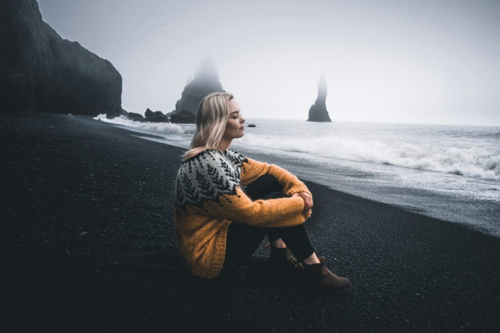 girl sitting by the sea stormy weather