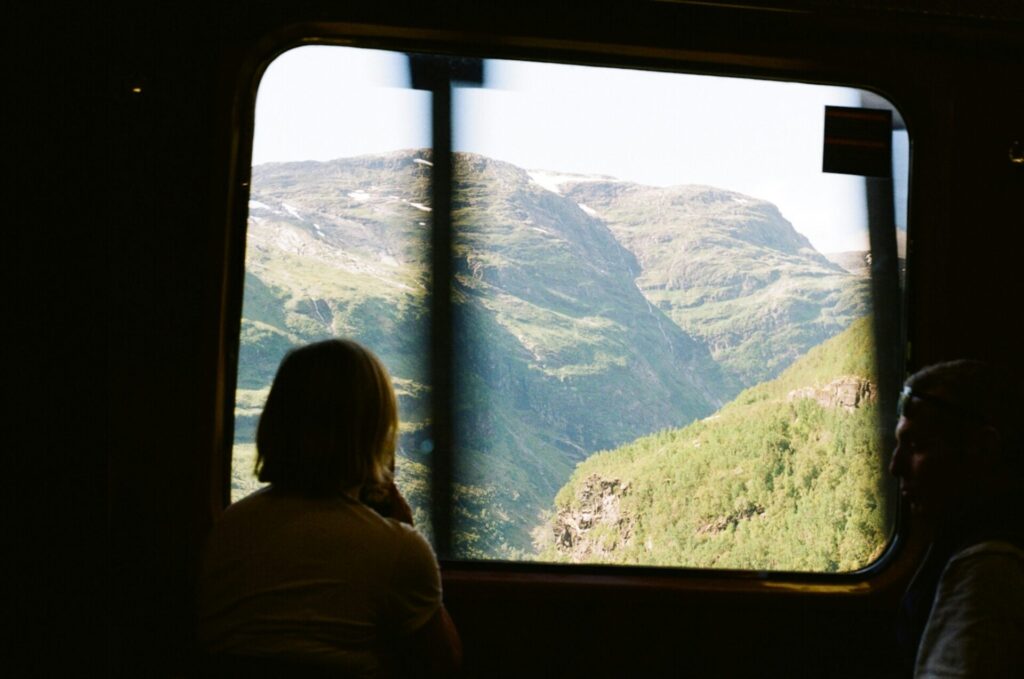 woman in a train looking at view of mountains