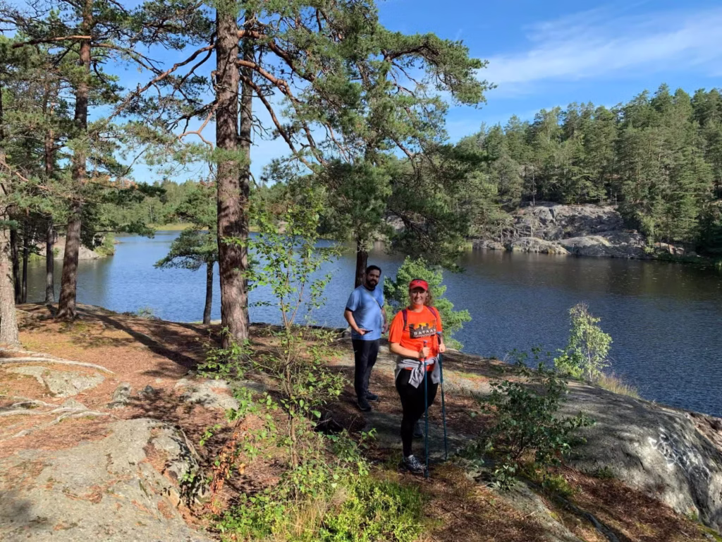 people hiking by water and trees