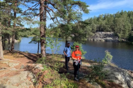 people hiking by water and trees